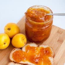 Slice of bread and mason jar with apricot jam.