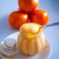 Orange curd in a spoon on a mason jar