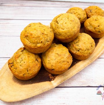 A stack of muffins on a wooden board.