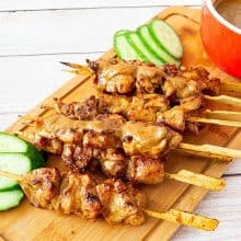 Satay skewers on a wooden board.