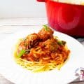 A plate of pasta bolognese with meatballs.