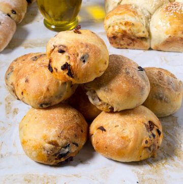 Olive rolls on a table with sun dried tomatoes.