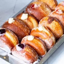 A tray with cream filled donuts.